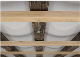 Justerskruv som steglöst fäster och justerar träkonstruktioner i tak och vägg